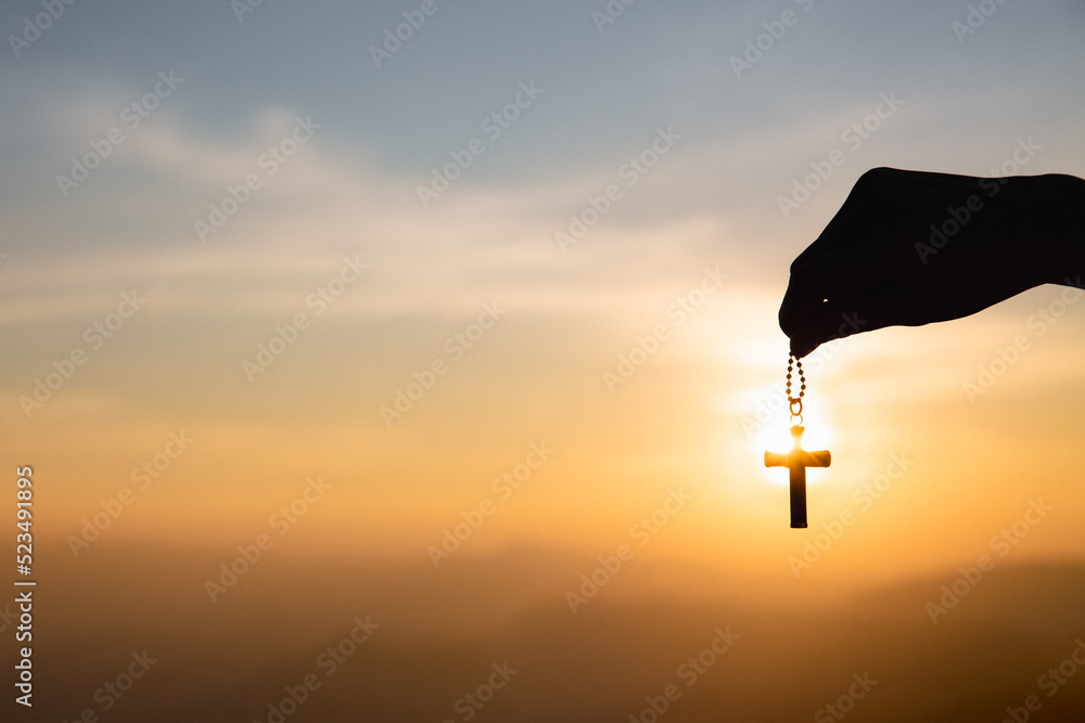 Religious concept, human hand holding a Christian cross necklace. jesus christ cross easter resurrection concept