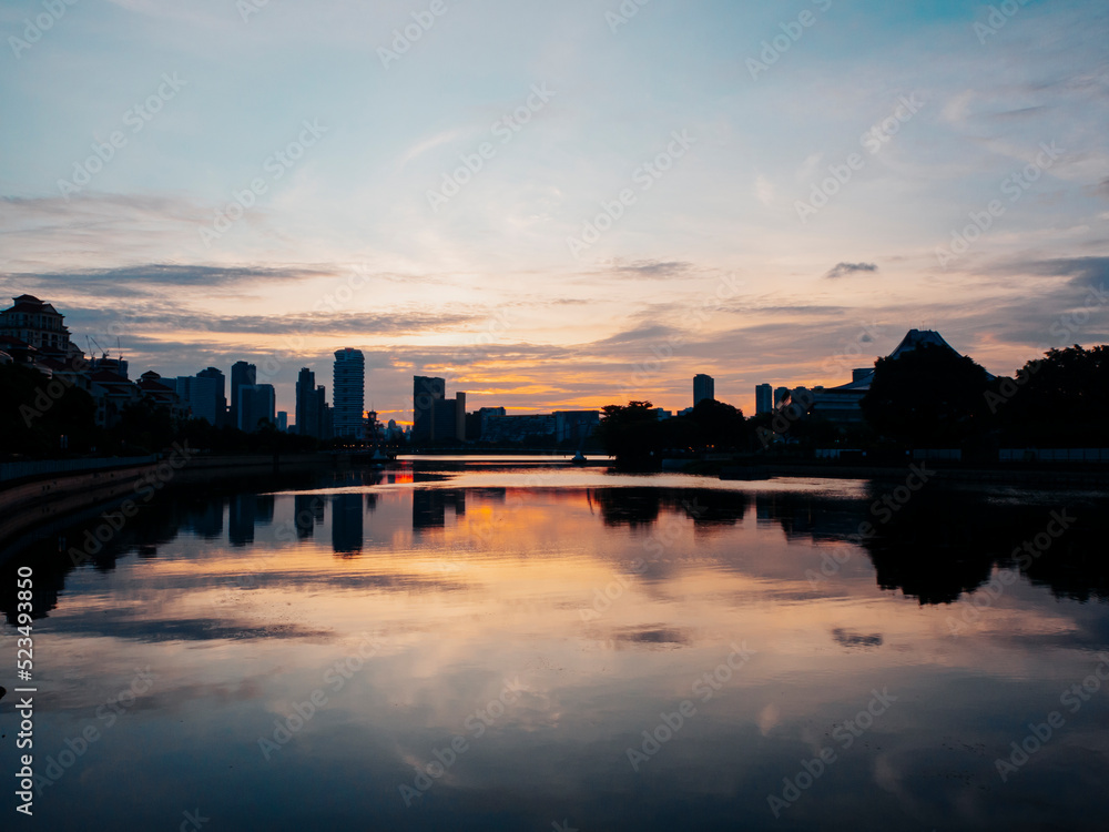 Sunset by the Kallang River in Singapore. Silhouette of residential apartment buildings in the background.