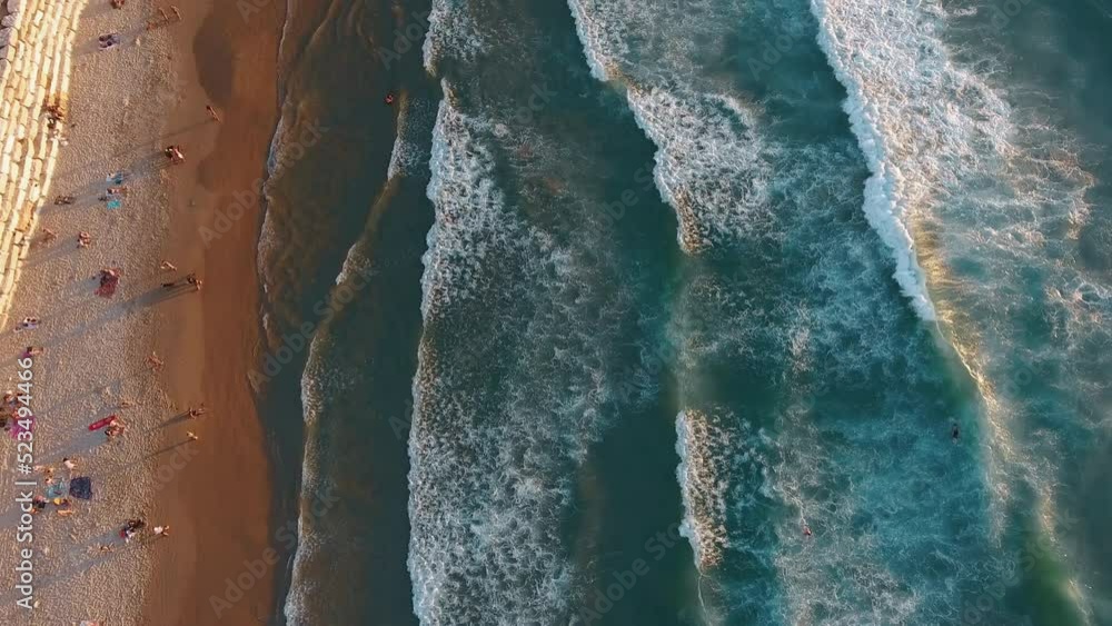 Aerial top down view of a beach with a population, flying forward Aerial top down view of a beach with a population, flying forward