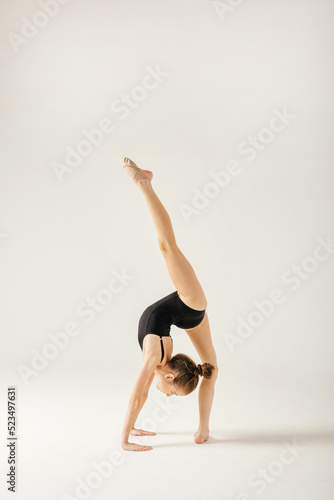 Girl gymnast performs a jump to the top.