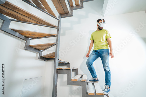 Young bearded man using virtual reality goggles before starting renovations in his townhouse