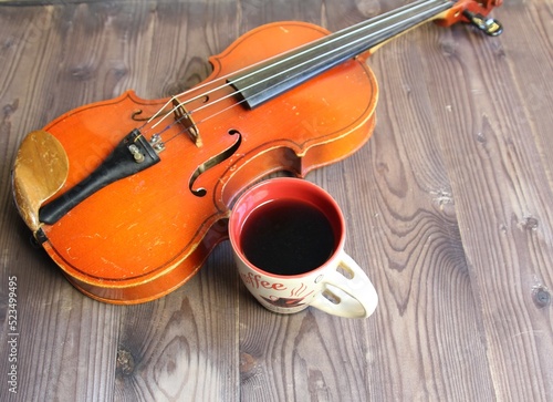 still life of cup of coffee and violin on wooden background