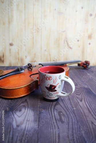 still life of cup of coffee and violin on wooden background