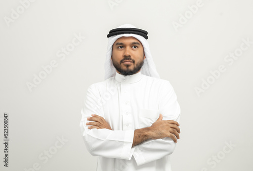 Portrait of arabic man with kandura dress on isolated white background. Arab business people thinking.