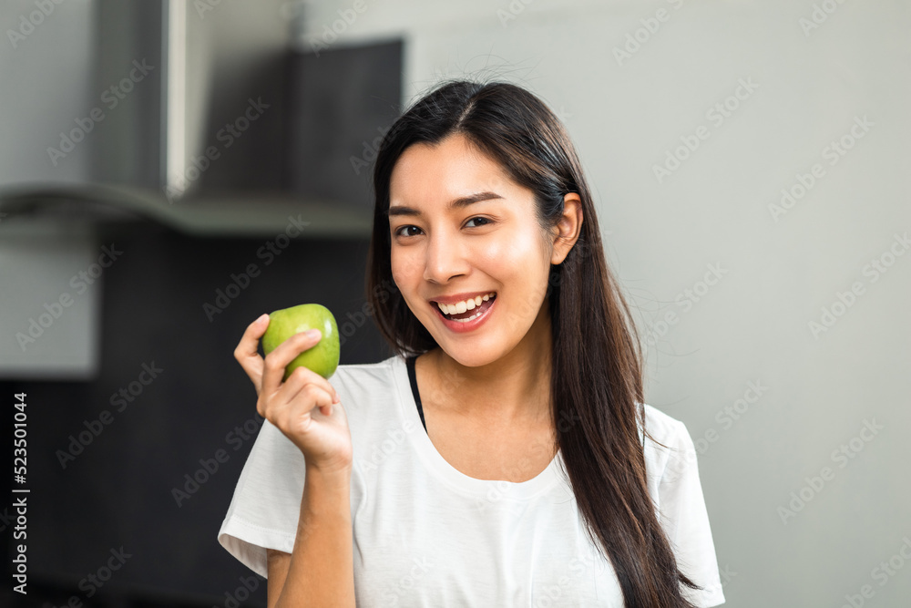 Young female eating greens apple in weight loss diet and wellness on table. Beautiful woman happily eat a healthy salad breakfast in kitchen in the morning. Diet food concept. Young female eating greens apple in weight loss diet and wellness on table. Beautiful woman happily eat a healthy salad breakfast in kitchen in the morning. Diet food concept.
