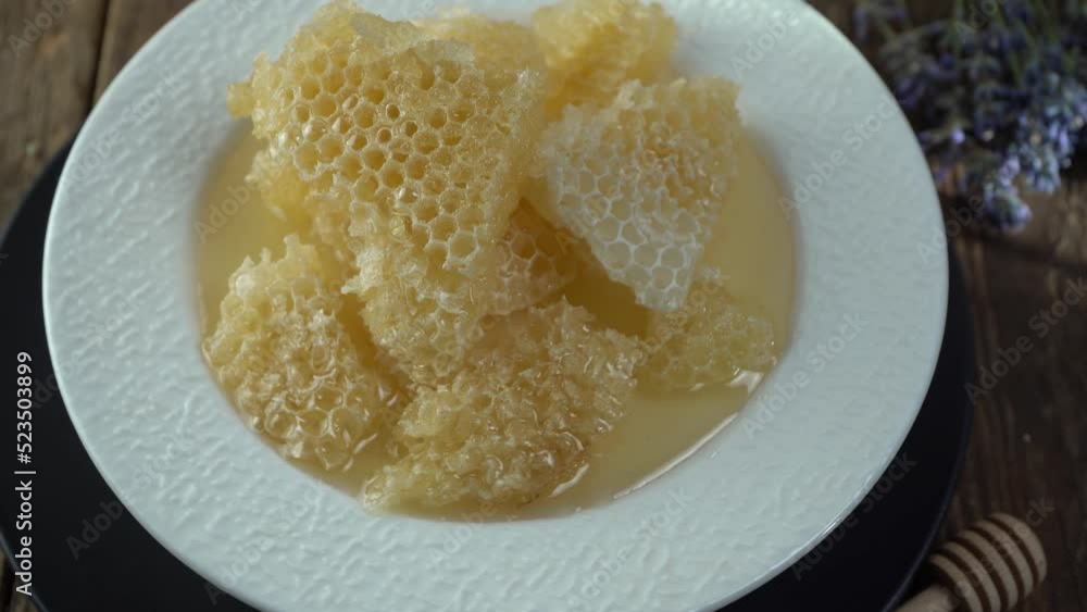 Honey and honeycombs on a white plate. Sweet food in a bowl on the table. A product of beekeeping. Honey and honeycombs on a white plate. Sweet food in a bowl on the table. A product of beekeeping.