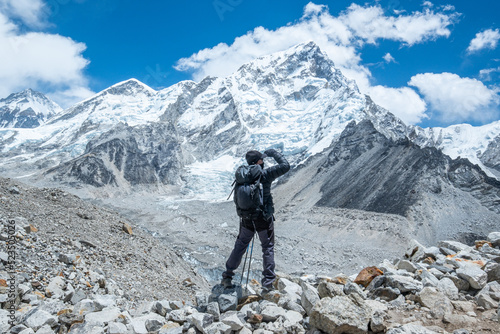 Male backpacker enjoying the view on mountain walk in Himalayas. Everest Base Camp trail route, Nepal trekking, Himalaya tourism. © CravenA