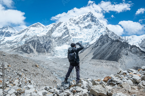 Male backpacker enjoying the view on mountain walk in Himalayas. Everest Base Camp trail route  Nepal trekking  Himalaya tourism.