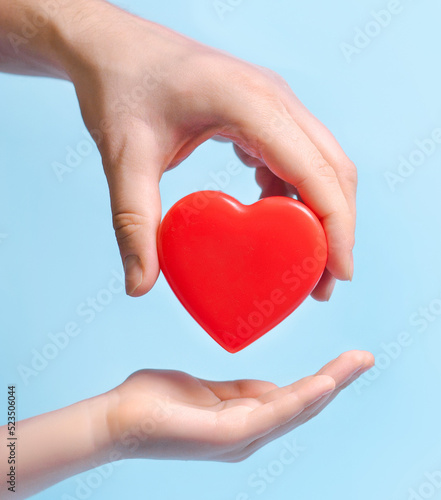 Hand person giving a heart to another person on blue background.Poster  banner  copy space for text