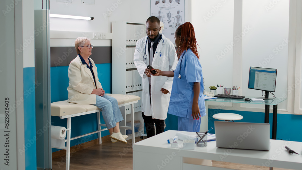 Obraz premium African american medic giving bottle of pills as prescription treatment, using antibiotics medication to help patient with healthcare recovery. Drugs medicament at medical appointment.