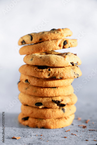 Oatmeal cookies with chocolate folded in a stack on a gray background. Close-up. 