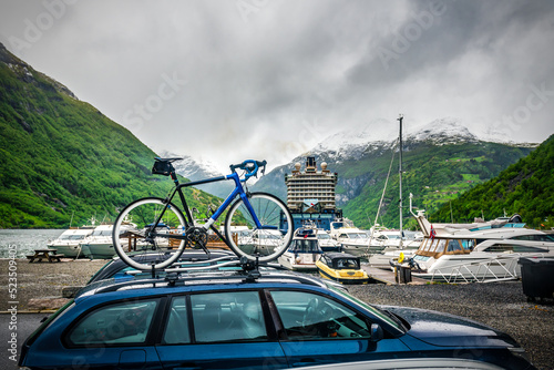bicycle mounted on roof of a car against cruise ship