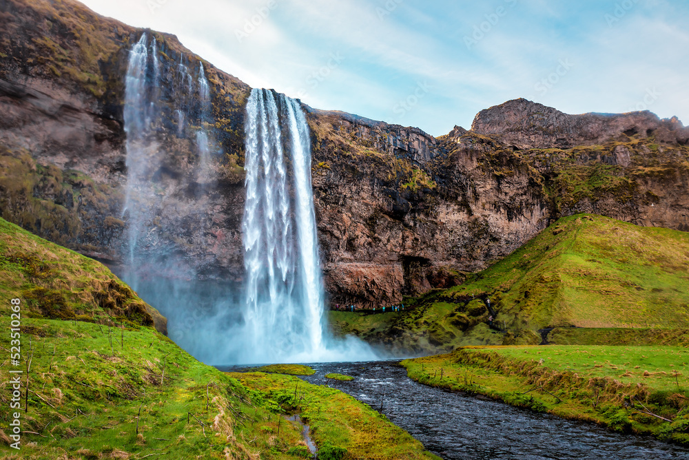 Obraz premium Seljalandfoss waterfall and green lawn in Iceland