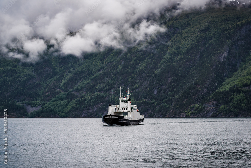The ferry sails on the surface of a fjord in Norway