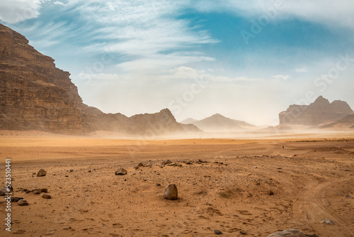 The wind raises the dust in desert photo