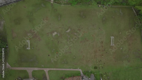 Top down aerial footage of a group playing soccer in a field. photo