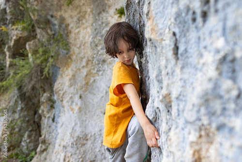 A little rock climber is training to climb a boulder