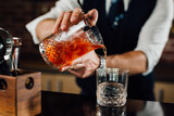 close up of barman pouring drink in glass