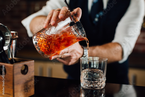 close up of barman pouring drink in glass photo