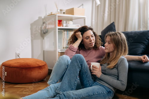 mother talking with her daughter sitting in living room