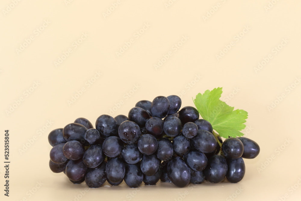 Fototapeta premium A cluster of red grapes isolated. Cream background. 