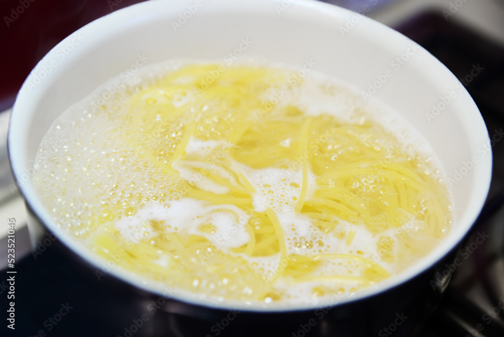 Cooking pasta in saucepan on stove, closeup Cooking pasta in saucepan on stove, closeup