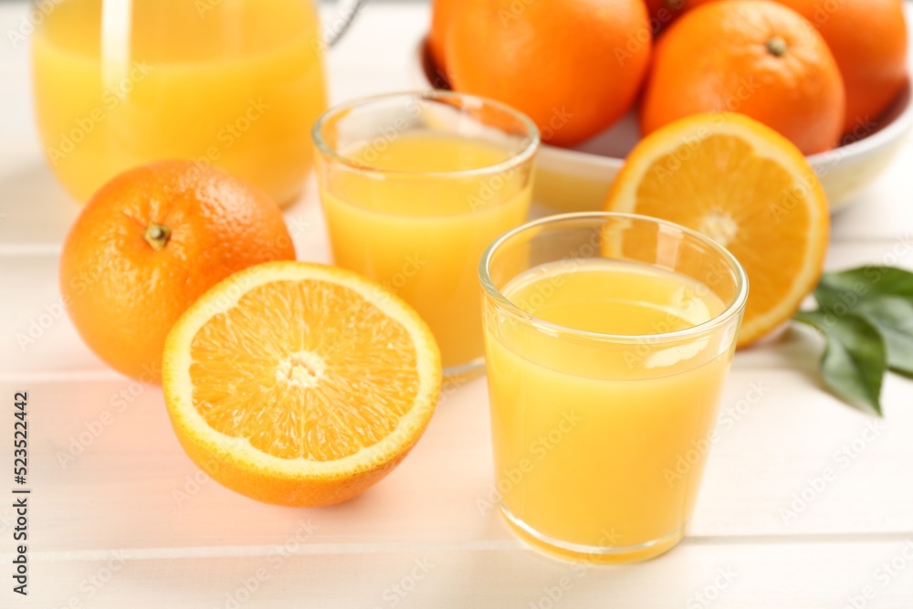 Delicious orange juice and fresh fruits on white wooden table, closeup Delicious orange juice and fresh fruits on white wooden table, closeup