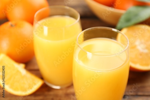 Delicious orange juice and fresh fruits on table, closeup