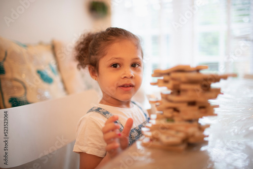Portrait cute girl playing with wood puzzle pieces photo