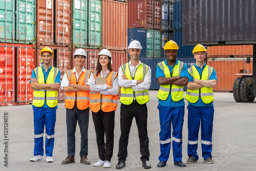 Portrait group of male and female worker working in container terminal. Attractive business man and woman laborer stand with confidence after process orders at warehouse logistic in cargo freight ship