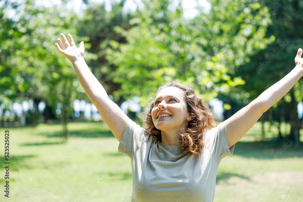 Woman breathing fresh air outdoors in summer, celebrating while out in nature Woman breathing fresh air outdoors in summer, celebrating while out in nature