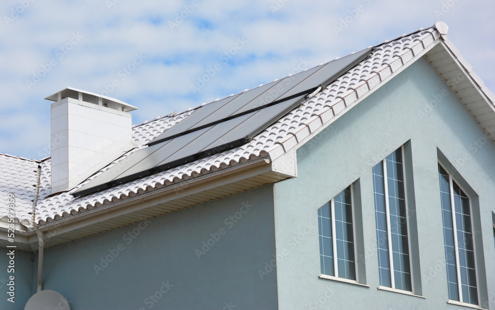 White roof house for energy saving. Close up on modern house energy efficiency white roof with solar water heating panels. White Roof Coatings.