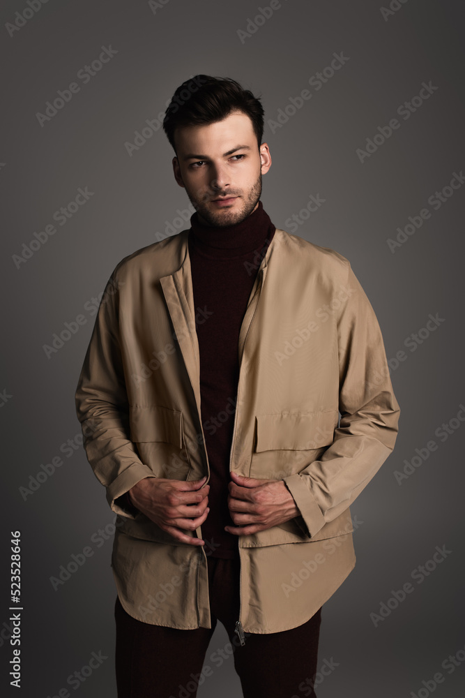 Obraz premium Stylish man in autumn outfit posing isolated on grey.