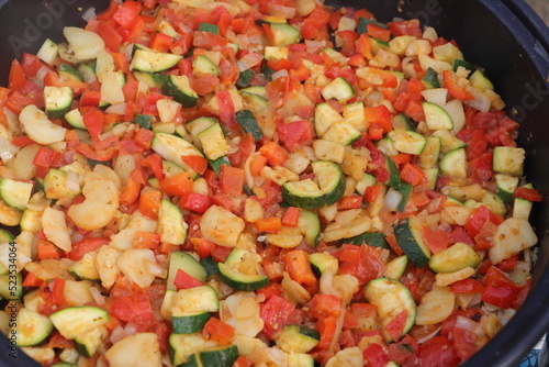 a vegetable pan with courgettes, onions, tomatoes, potatoes and peppers