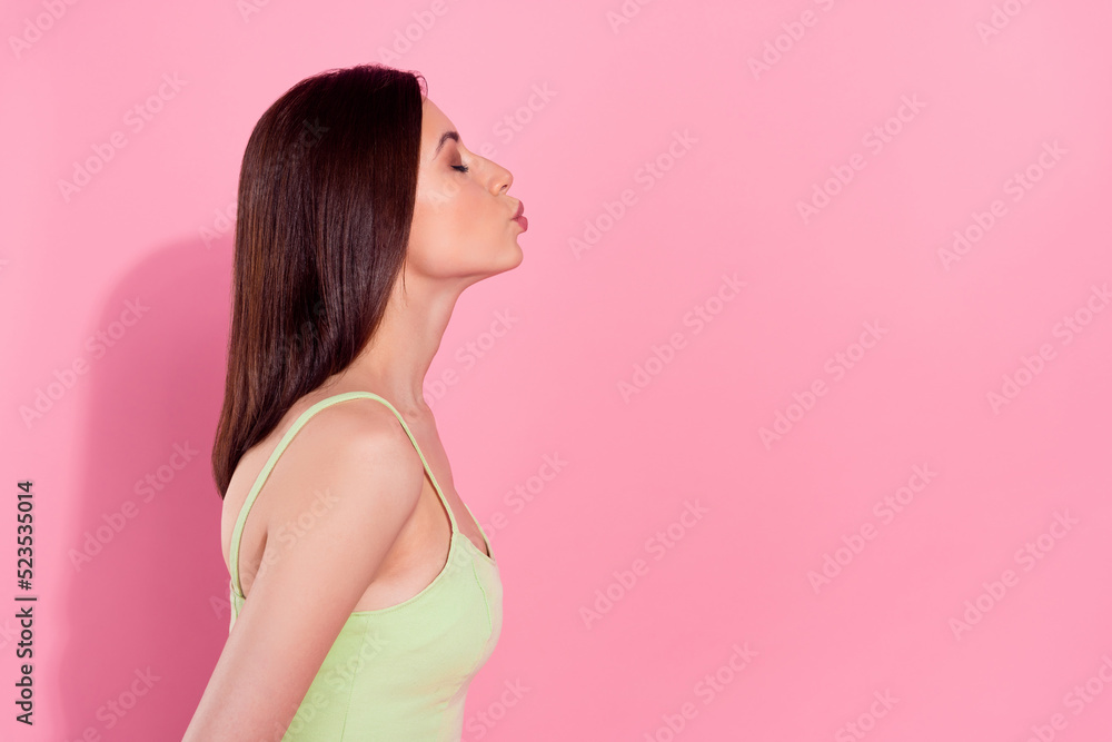 Photo of adorable dreamy young lady wear green dress sending kiss empty space isolated pink color background Photo of adorable dreamy young lady wear green dress sending kiss empty space isolated pink color background
