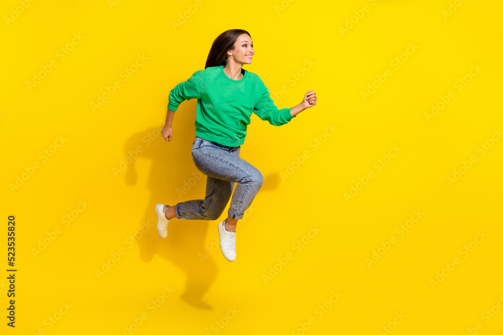 Full length photo of active young lady run fast hurry shopping mall sales wear stylish green sportswear isolated on yellow color background
