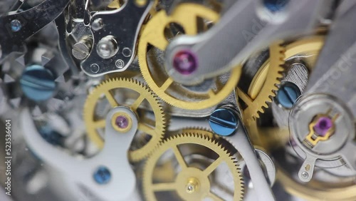 Watch mechanism clockwork with golden cogwheels and jewels running  on silver steel internal closeup gear movement working with tourbillon detail and precision swiss made mechanical watch semi manual 