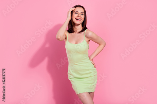 Photo of adorable excited young lady wear green dress smiling laughing isolated pink color background