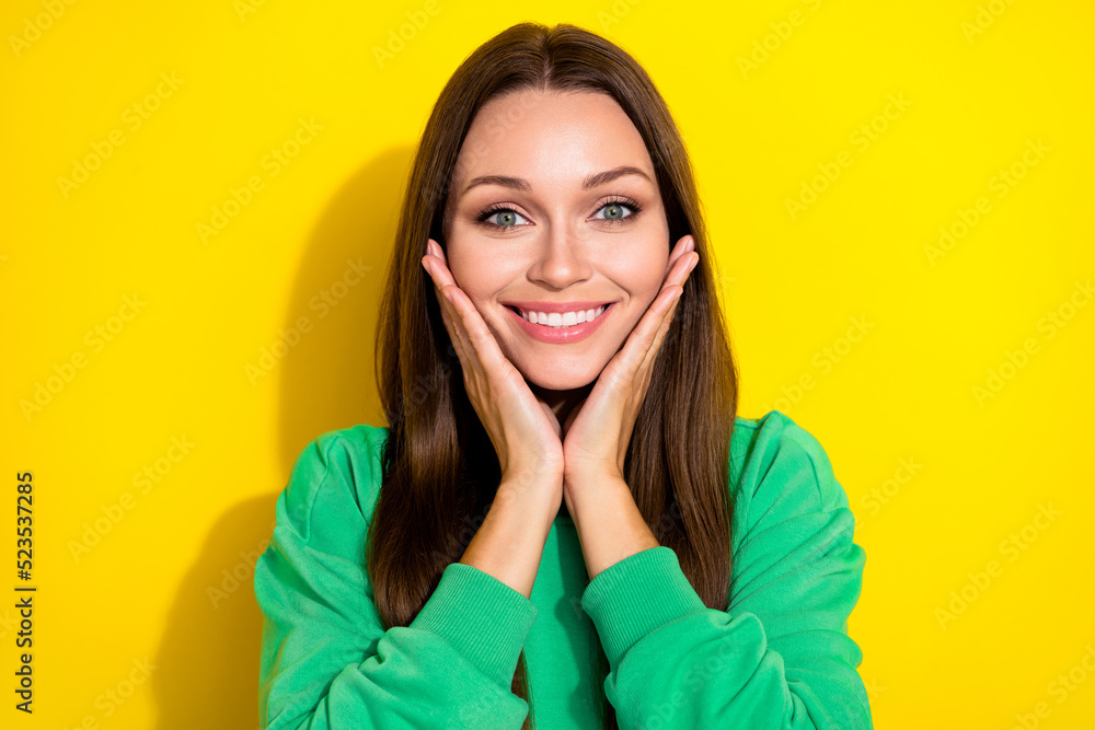 Portrait of pretty positive person arms touch cheeks have good mood isolated on yellow color background Portrait of pretty positive person arms touch cheeks have good mood isolated on yellow color background