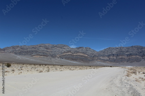 Road leading to mountains with colorful and unique rock formations in Death Valley National Park