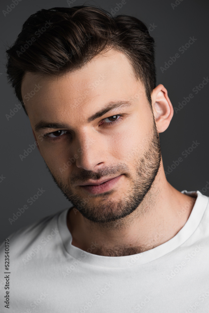 Obraz premium Portrait of young bearded man looking at camera isolated on grey.