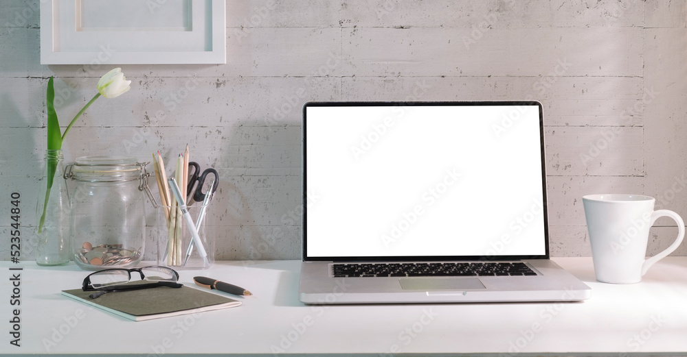 Laptop with blank screen, coffee cup, picture frame and notebook on white table. Laptop with blank screen, coffee cup, picture frame and notebook on white table.