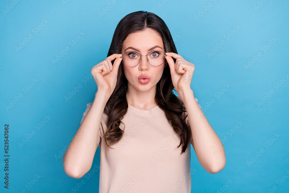 Obraz premium Photo of funky funny young girl with bad eyesight vision try on spectacles isolated on blue color background