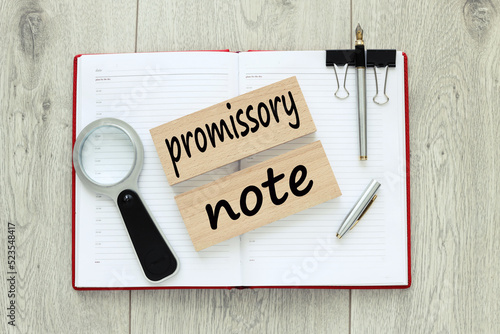 Promissory note. wooden blocks with text. on a red notebook photo