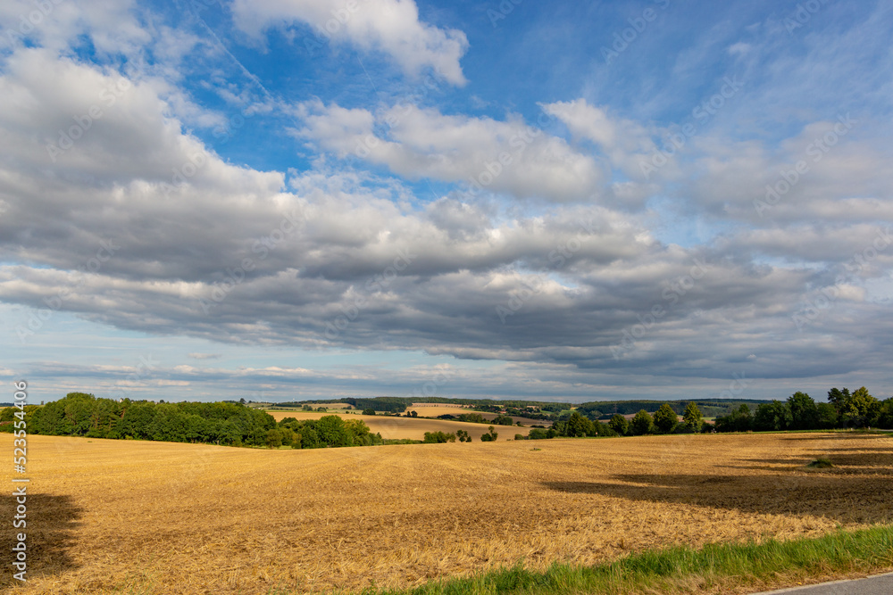 Countryside panorama, rolling hills and wheat fields at sunset. Czechia