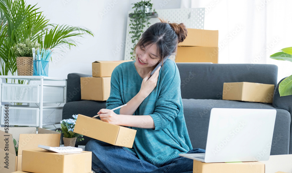 Startup small business SME, Entrepreneur owner using smartphone or tablet taking receive and checking online purchase shopping order to preparing pack product box. Selling online ideas concept Startup small business SME, Entrepreneur owner using smartphone or tablet taking receive and checking online purchase shopping order to preparing pack product box. Selling online ideas concept