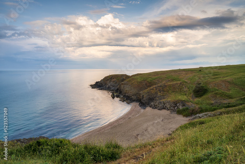 Picturesque view with beautiful sunset sky with small wild beach at the rocky coastline of the Black Sea.