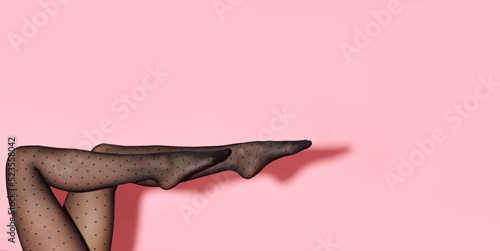 female legs in black tights on pink background. photo