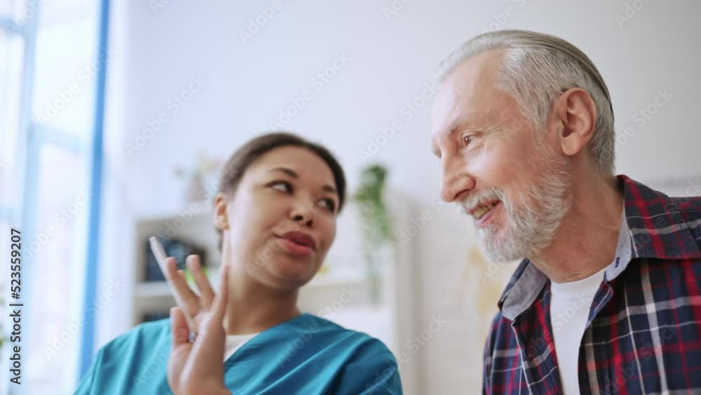 Female doctor explaining x-ray image results to senior man, diagnostic center Female doctor explaining x-ray image results to senior man, diagnostic center
