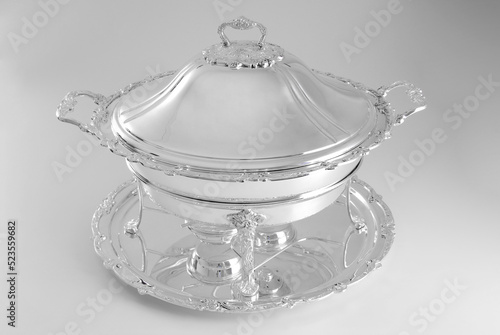 Antique round silver rechaud on a silver tray, isolated on white photo